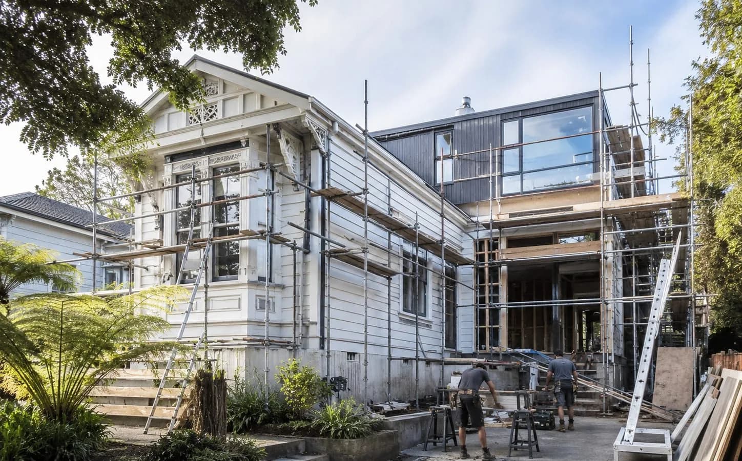 Illustrative house renovation with scaffolding and a team on site